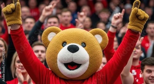 A large crowd cheers on a person wearing a bear mascot costume