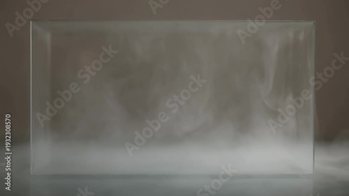 Mysterious white vapor gracefully swirling inside a clear rectangular glass container, creating an atmospheric abstract visual texture perfect for science, design, and conceptual projects