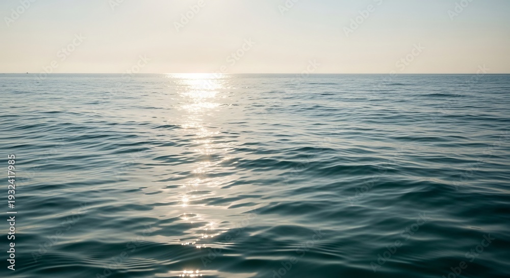 Fototapeta premium Calm Ocean Surface Reflecting Golden Sunlight at Dusk.