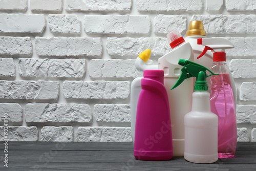Canvastavla House cleaning supplies on a wooden table against a brick wall background