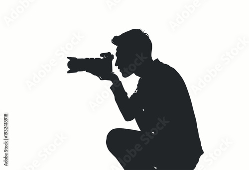 Silhouette of a focused photographer in action, capturing moments through the lens against a stark white background, showcasing the art of photography and concentration.