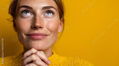 Hopeful Young Woman with Upward Gaze and Clasped Hands

