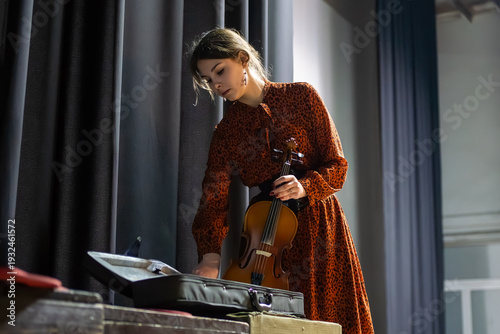 Fotografia female violinist takes out her violin while standing backstage