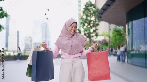 Portrait of Muslim woman shopping goods outdoors in department store. 