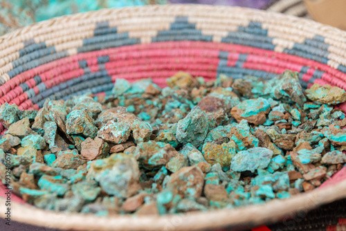 Photos Blue raw turquoise stones on a traditional Native American woven bowl plate