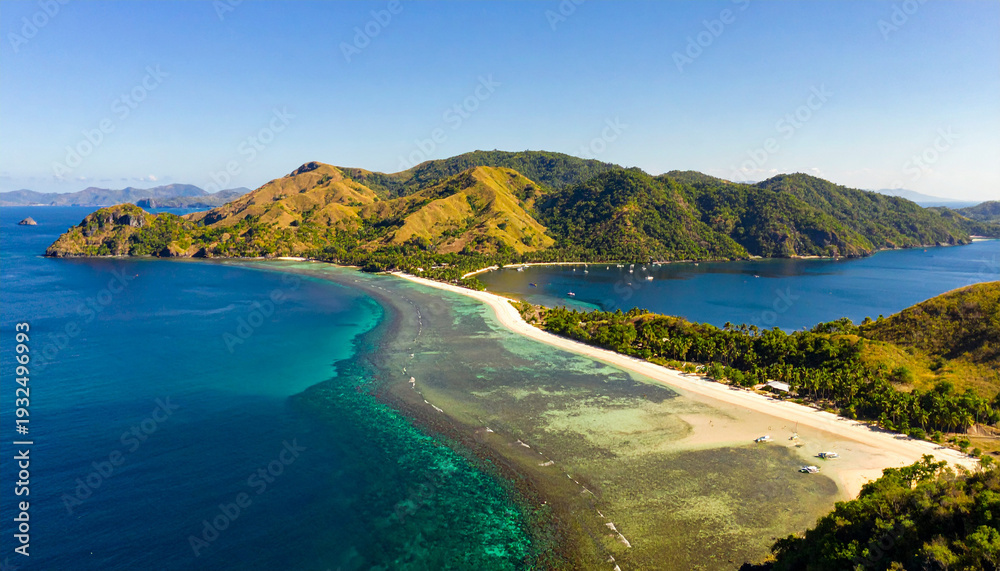 Obraz premium Experience paradise with this stunning aerial shot of a white sand beach, crystal clear turquoise waters, and lush green mountains. Perfect for travel and nature inspiration.