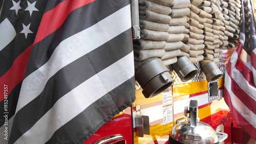 Red thin line black american flag on firefighter truck. Hose of firetruck and fire fighters symbol in New York, United States. 911 remembrance, fire department engine vehicle. September 11 Patriot Day