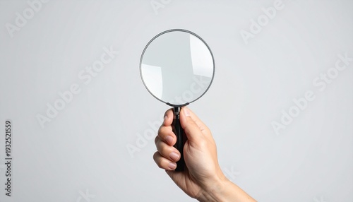 Hand Holding a Magnifying Glass Against a White Background Exploring Clarity Investigation Research and Discovery.