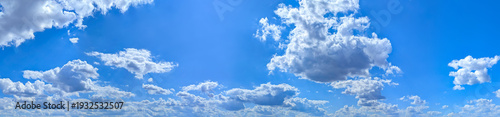 Panel kuchenny z motywem A high-resolution image showcasing a vibrant blue sky filled with scattered white cumulus clouds. The natural daylight highlights the soft textures of the clouds.
