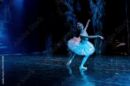 Woman ballerina performing on stage in ballet performance.