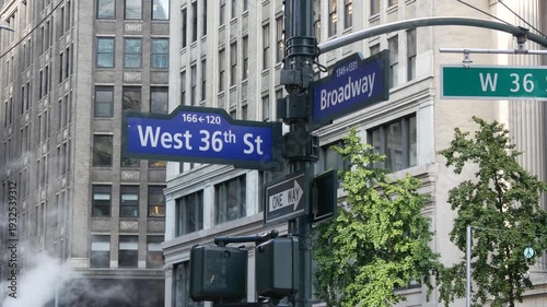 New York City Broadway and 36 street sign on Manhattan, United States. Urban road sign in american city. Traffic sign in Midtown of NYC. Building architecture, district near Herald Square. Hot steam.