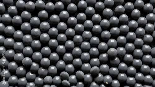 Close-up full frame texture of dark grey cylindrical pellets, likely activated carbon or industrial filter granules for purification.