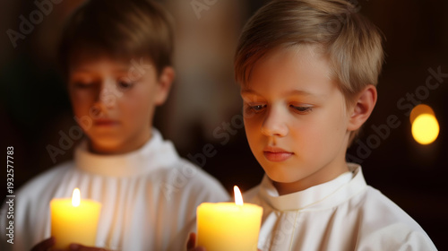 Two young boys in white robes holding lit candles in church, youth worship participation, children's candlelight service, altar server moment, faceless young worshippers, defocused background,