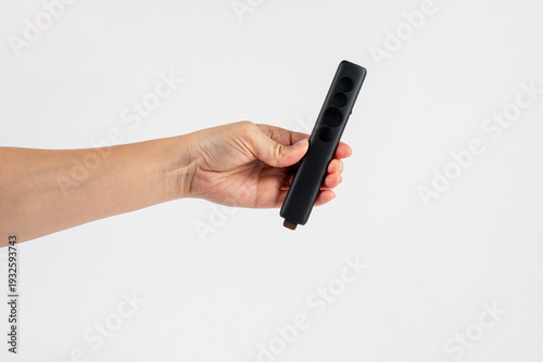 Wallpaper Mural A small black remote control in a hand, against a white background. Torontodigital.ca