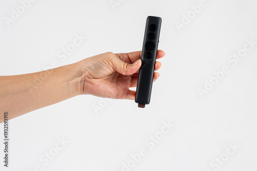 Wallpaper Mural A small black remote control in a hand, against a white background. Torontodigital.ca