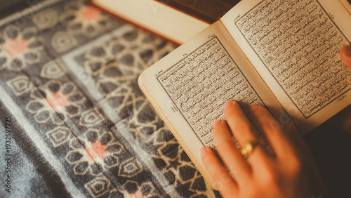 Φωτογραφία Hand touching open Quran on prayer rug, symbolizing deep spiritual connection, Islamic faith, devotion, and religious learning during prayer or study