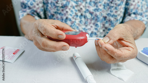 Photos Close up of senior woman using blood glucose meter to check sugar level at home