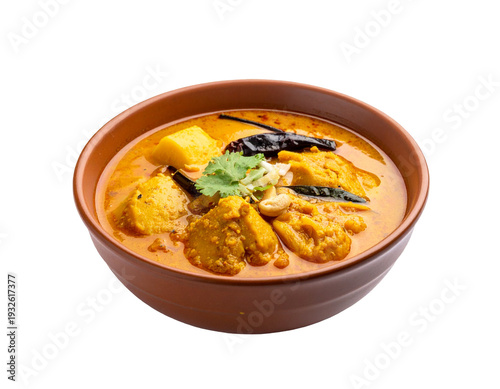Savory curry with chicken chunks and peppers in a round brown bowl