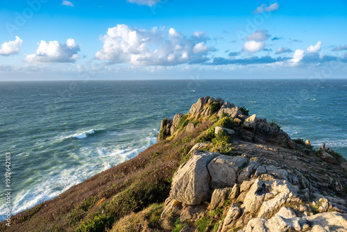 Photographie du Point du Grouin à Cancale en Bretagne (France), montrant les falaises rocheuses dominant l’océan Atlantique. Station d’observation et sentier côtier surplombant une mer agitée, vagues 