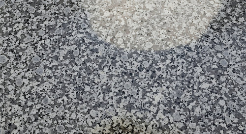 Close up view of a grey and white textured carpet with a large circular pattern on the surface.