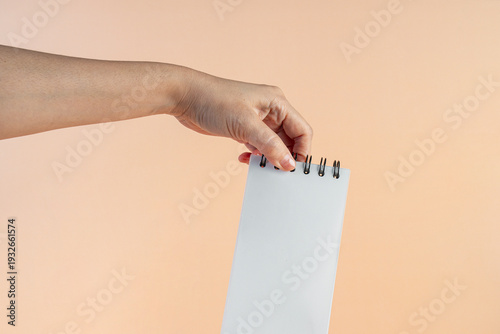 Wallpaper Mural A white notebook in hand against a cream background. Torontodigital.ca