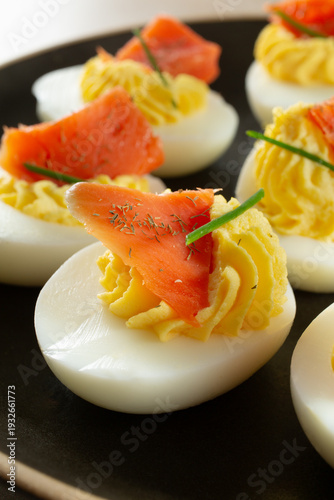 A closeup view of some deviled eggs, featuring smoked salmon.
