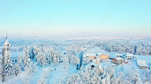 Snow covered village and church in winter morning light
