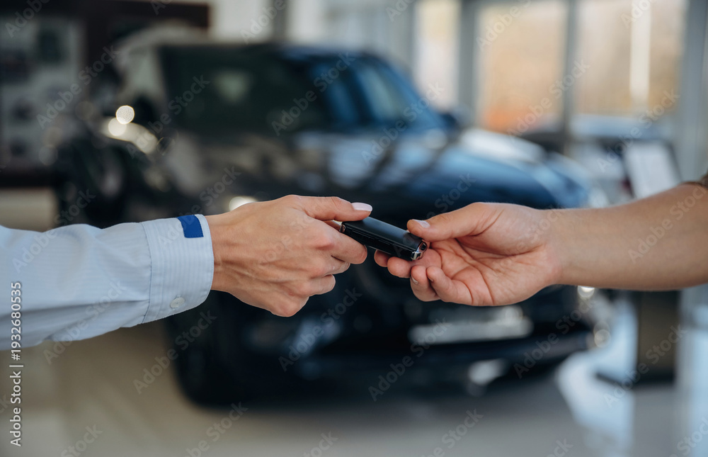Obraz premium Ownership conception. Close up view of woman's and man's hands that are taking the keys for new car