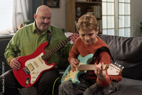 Fotografia Caucasian middle aged man teaching Caucasian boy playing electric guitars togeth