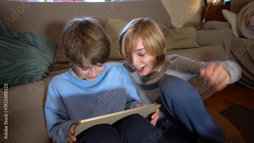 Two boys playing together on a digital tablet