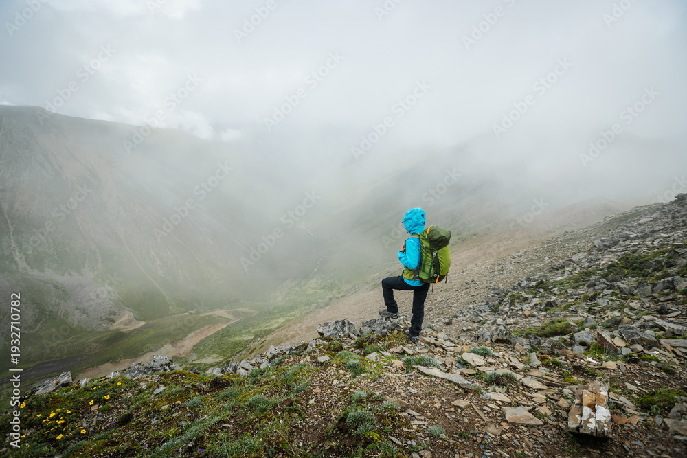 Obraz premium Woman hiking on high altitude mountain top