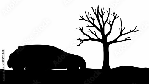 Silhouette of car parked under bare tree at dusk