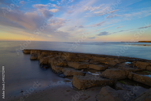 Sunset over Beadnell Bay at low tide,  Northumberland, England, UK.