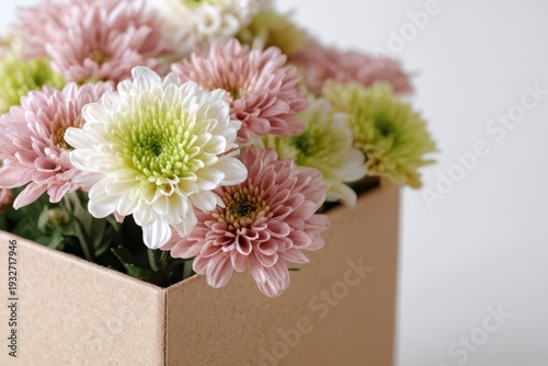Present. Beautiful flowers in paper box. Flower bouquet blossom in cardboard delivery box. Neutral beige background. Sweet surprise for special occasion. Mother's Day, Valentine's, Women's Day Gift.