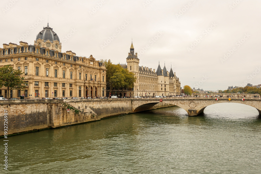 Obraz premium Seine River flowing past the Conciergerie, Palais de Justice, and Pont au Change bridge in Paris, France