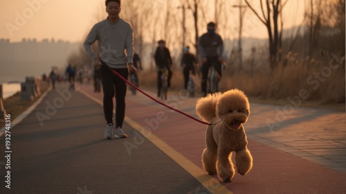A man walks in the park with a dog in the evening