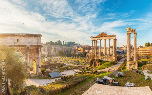 Panoramic view of Roman Forum with Arch of Septimius Severus and columns of Temple of Saturn at sunrise in Rome city, Italy. Ancient temple ruins, historic churches and archaeological remains