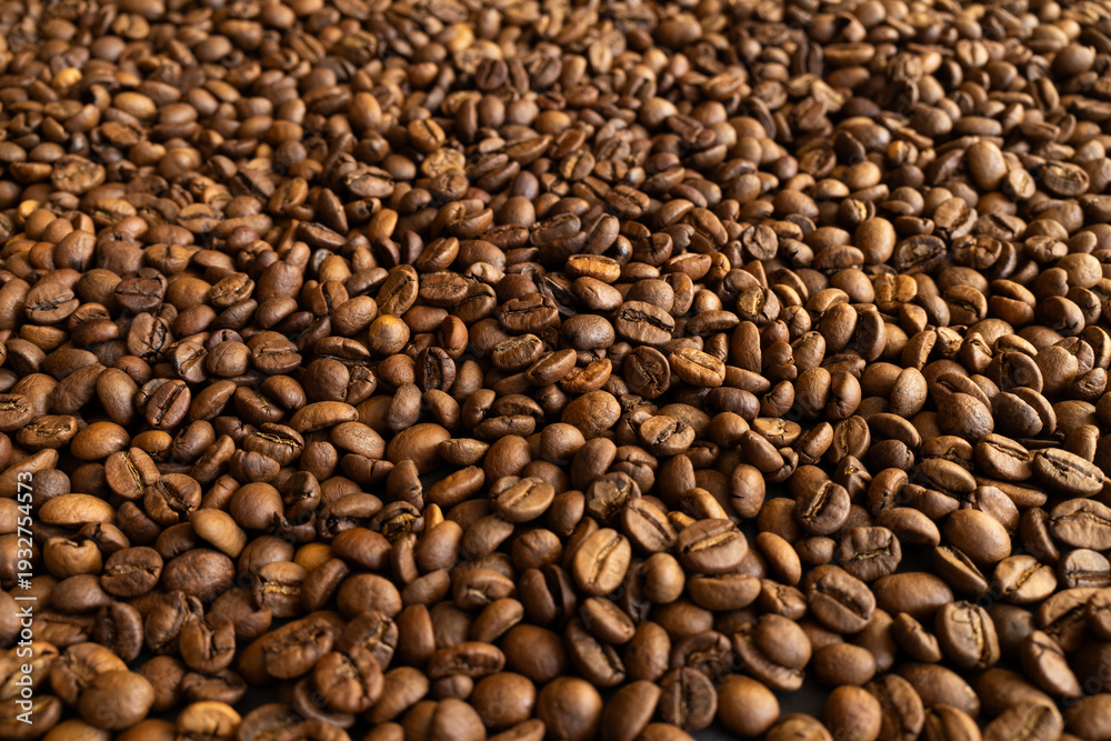 Fototapeta premium Close-up macro shot of roasted coffee beans filling the entire frame with rich brown tones