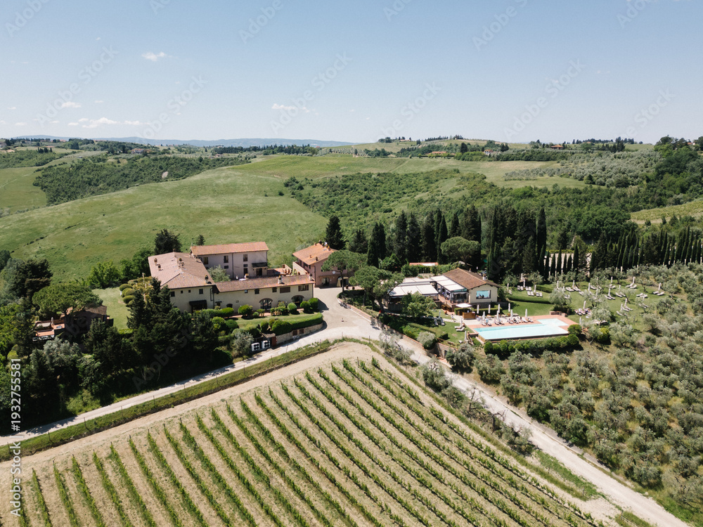 Fototapeta premium Tuscan vineyard estate with pool on rolling hills