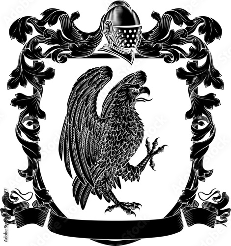 An eagle, hawk or falcon coat of arms or crest family heraldry medieval heraldic bird animal knight shield with helmet and acanthus filigree scroll ornament in a vintage woodcut style.