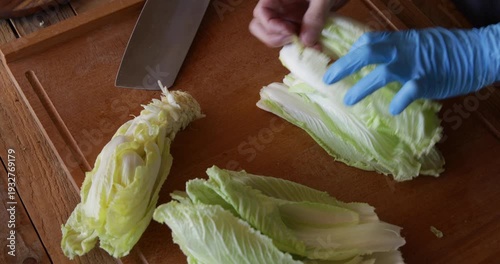 Chinese cabbage bai cai leaves lined up and cut with sharp angle shape using wide Asian style cleaver knife
