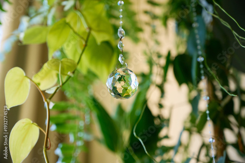Close-up of a transparent faceted crystal suncatcher in the shape of a ball.