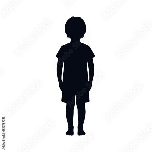 Silhouette of a young boy standing.