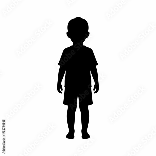 Silhouette of a young boy standing.