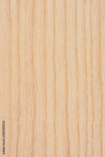 A flat top view of a light colored natural wood surface showing a smooth vertical grain pattern and fine organic details