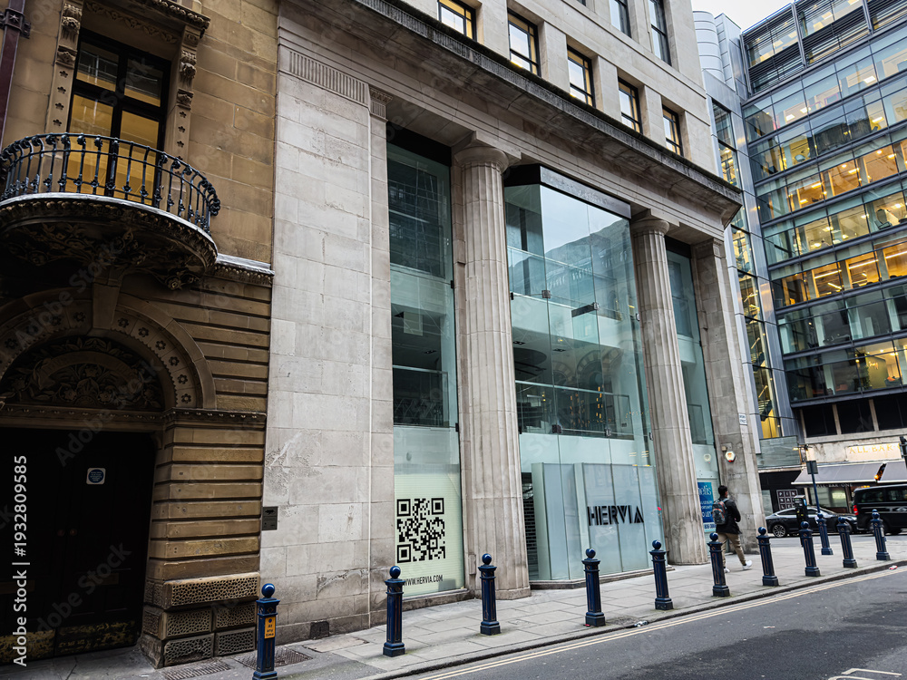 Fototapeta premium Historic and modern urban architecture in Manchester UK featuring a stone facade and glass HERVIA Store storefront