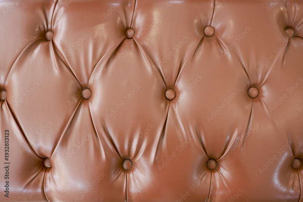 Fototapeta premium Close up background of brown tufted leather sofa texture. luxurious vintage upholstery pattern creating comfortable and elegant feeling with classic diamond detail
