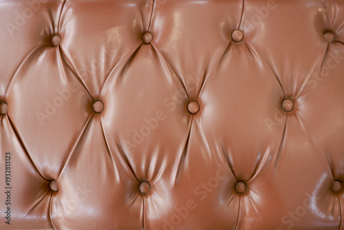Close up background of brown tufted leather sofa texture. luxurious vintage upholstery pattern creating comfortable and elegant feeling with classic diamond detail