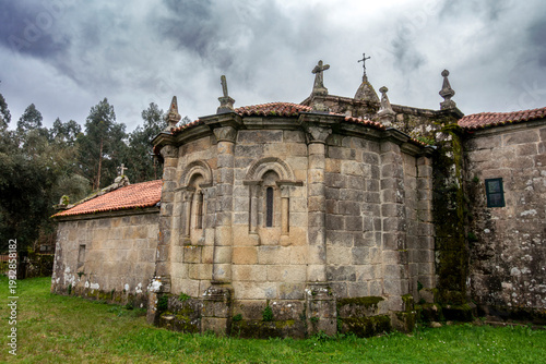 Venerable 12th-century Romanesque apse of San Martiño de Agudelo church with semicircular design and granite ashlar masonry, Barro, Pontevedra, Spain