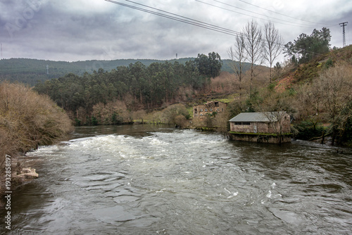 Turbulent winter swells of the Ulla River rushing through the lush valley of Herbon during a seasonal flood, Padron, Galicia, Spain